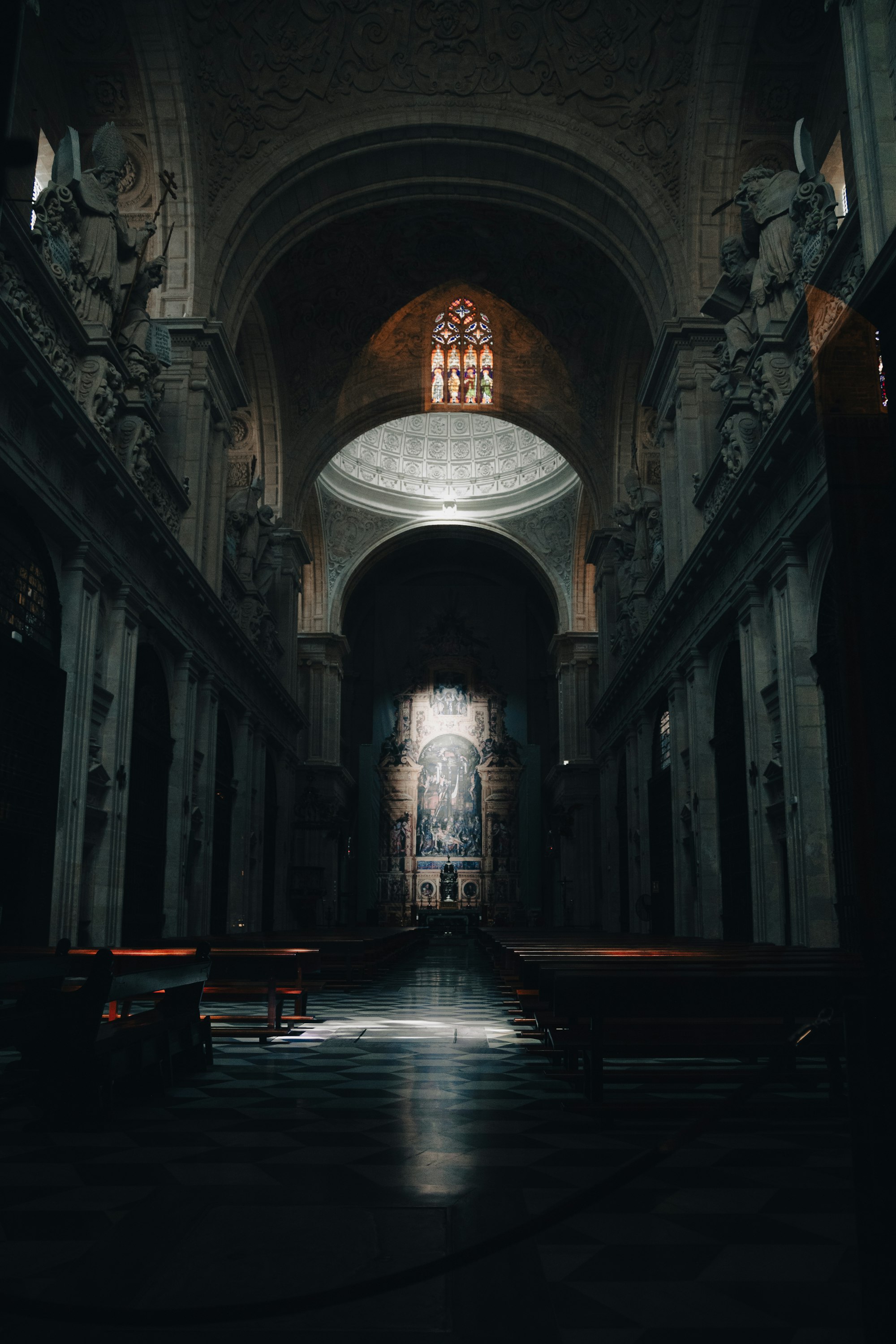 Empty church interior with rows of wooden pews and stained glass windows