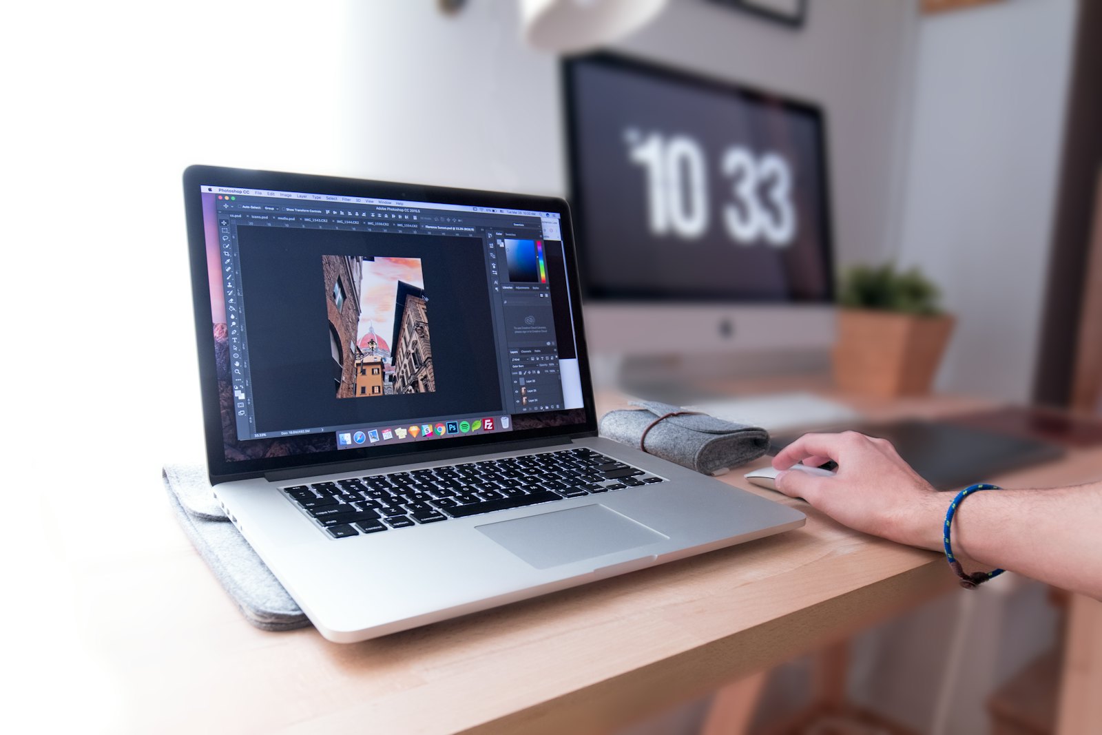 A MacBook open on a wooden desk workspace