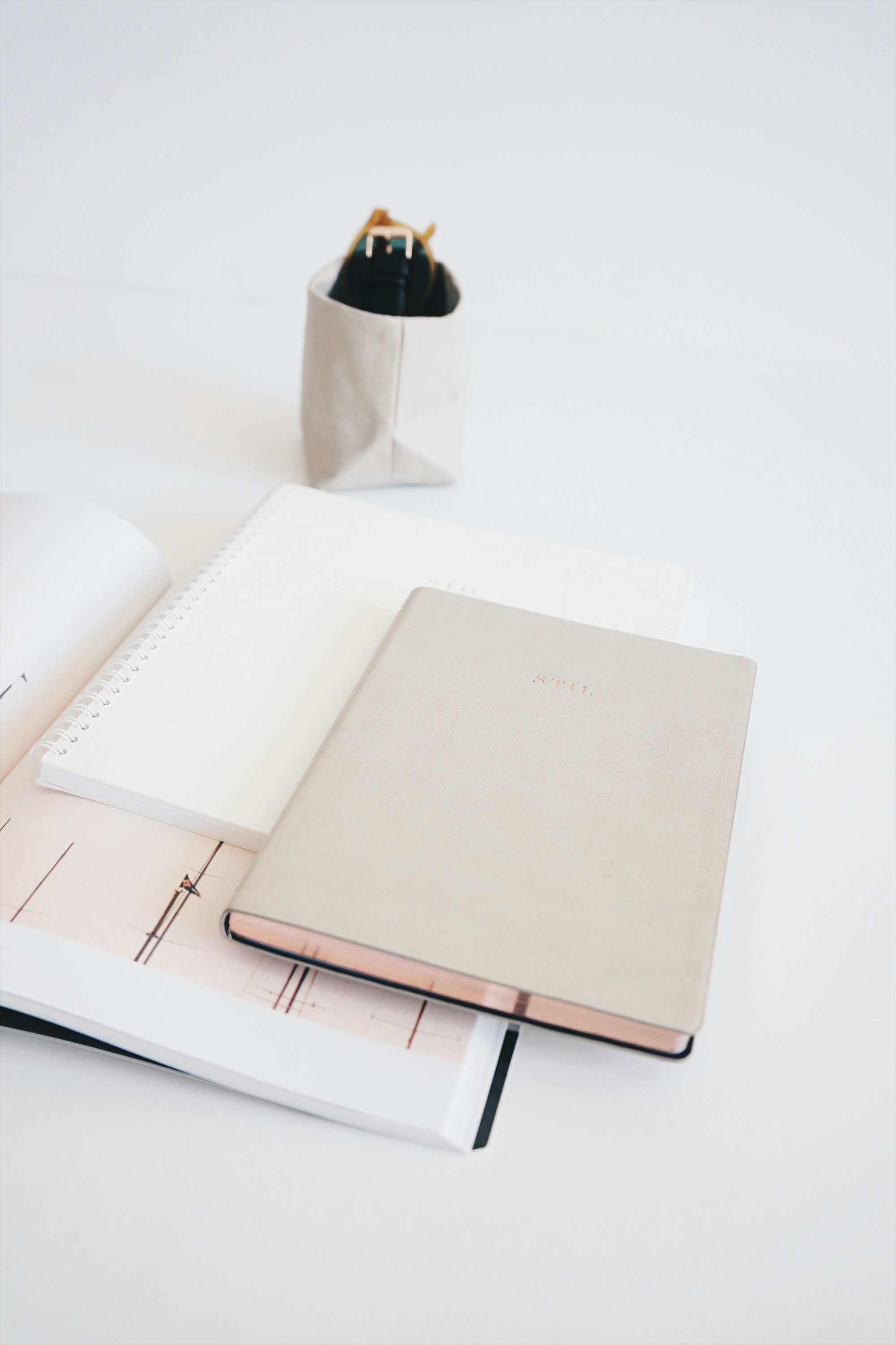 Three assorted-color notebooks lined up side by side on a desk