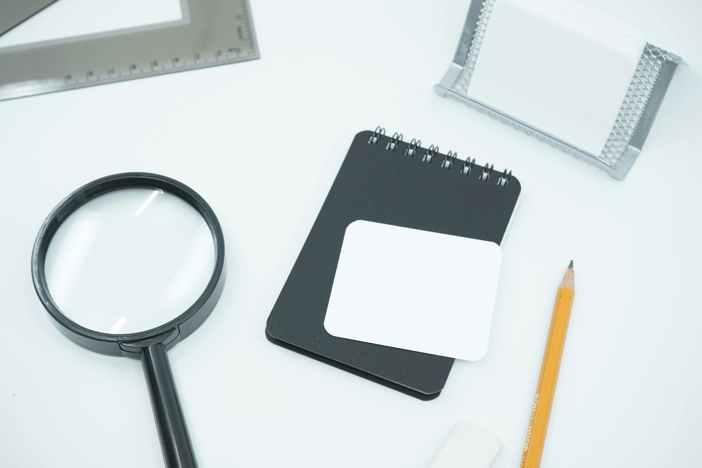 A black magnifying glass resting on a sheet of white paper